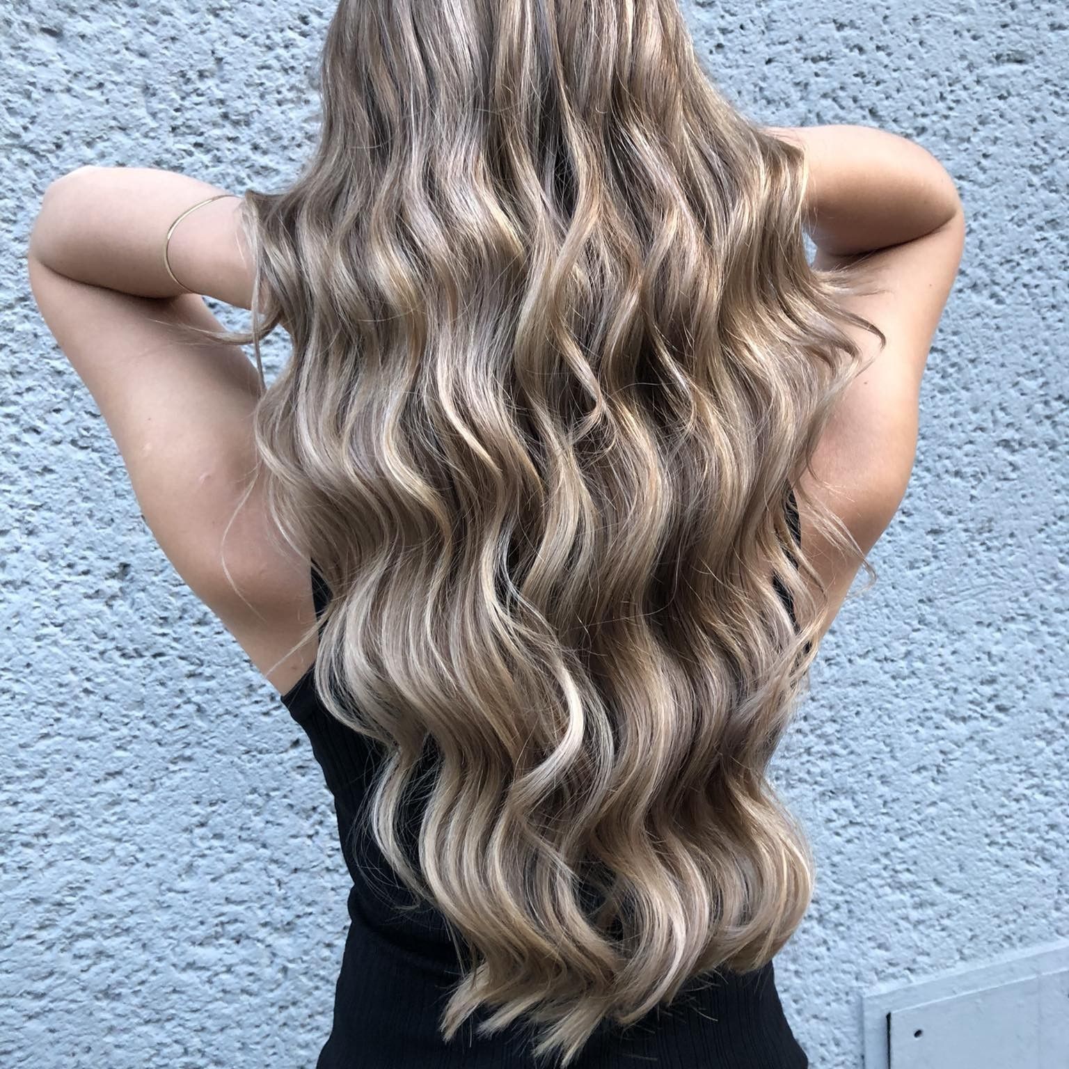 Długie blond włosy z balejażem ułożone w miękkie fale